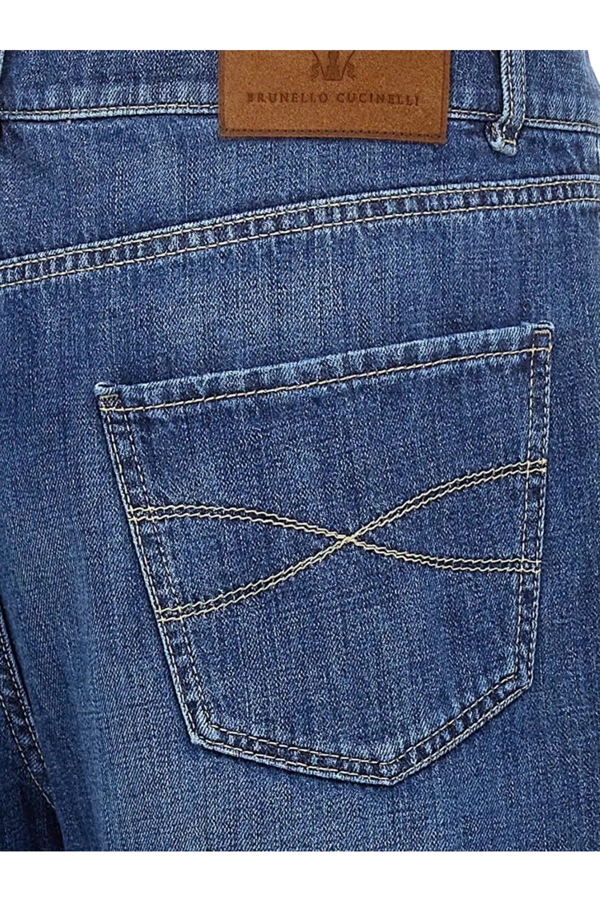 Blue denim brunello cucinelli men’s leisure fit cotton jeans back side with brown leather patch and white stitching on pocket