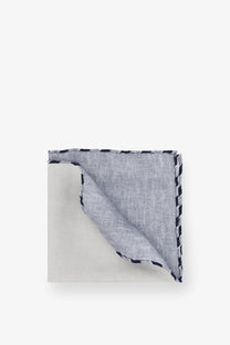 A neatly folded brunello cucinelli men’s silk pocket panama in light gray linen with black and white zigzag stitched border