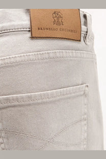 Light gray denim jeans with brown leather brunello cucinelli logo patch at the back from men’s stretch canvas trousers collection