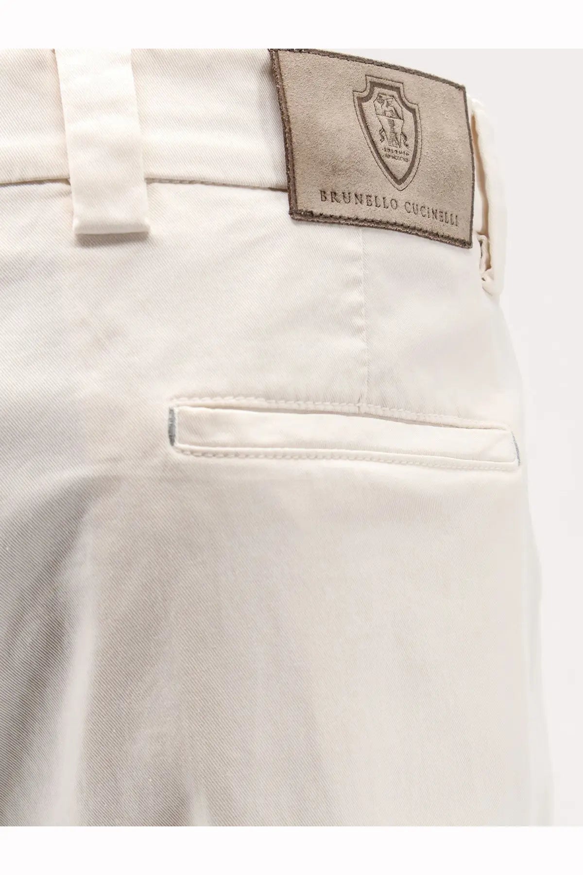 Cream-colored brunello cucinelli men’s stretch cotton chino pants with branded leather patch on the back waistband