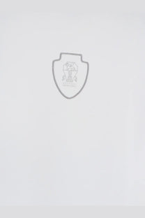 Gray shield-shaped emblem with detailed crest and text on white brunello cucinelli men’s technical fabric polo shirt
