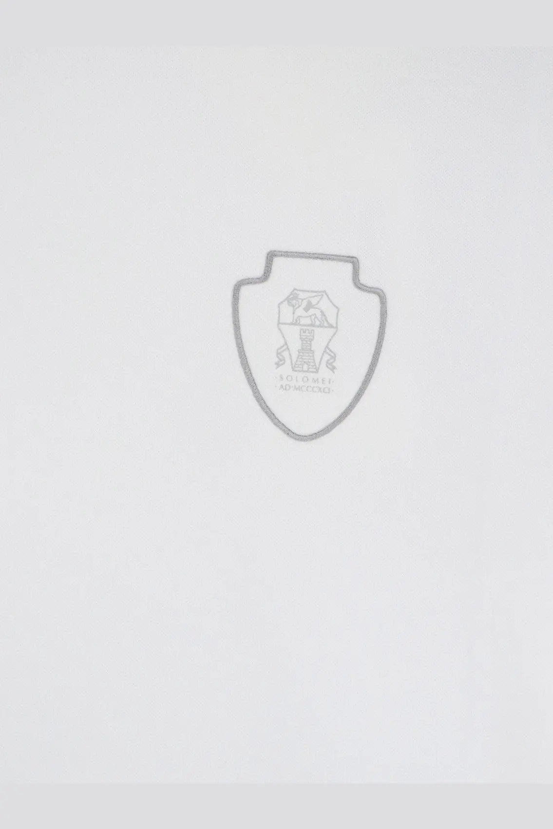 Silver shield-shaped emblem with central trophy and engraved text on brunello cucinelli men’s white technical fabric shirt