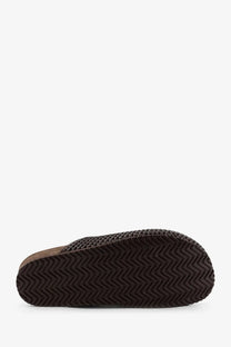 Dark brown rubber sole with zigzag tread pattern on brunello cucinelli women’s black leather sandals back view