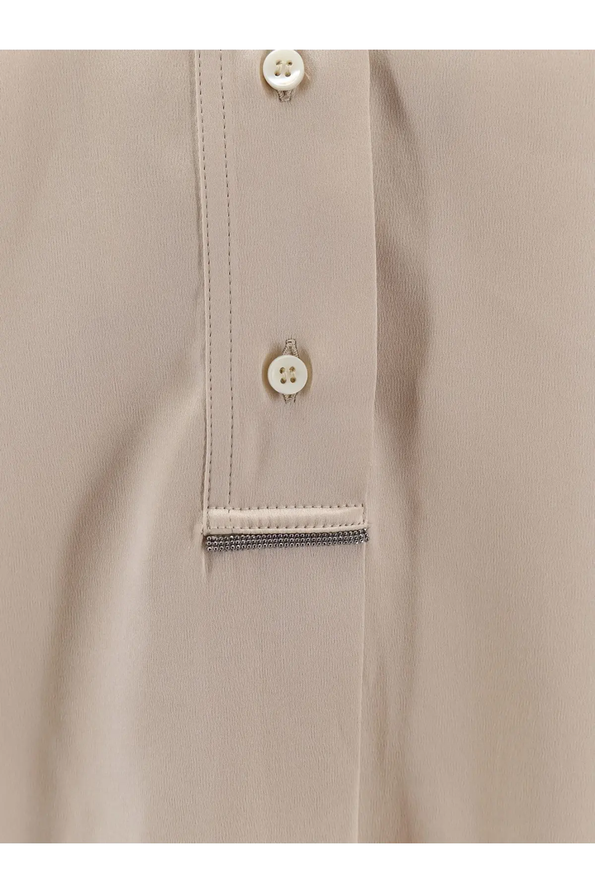 Brunello Cucinelli women’s beige silk blouse with white buttons and silver chain trim at the placket