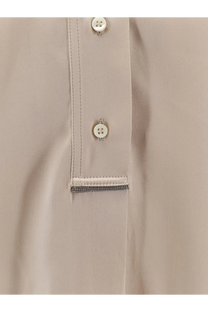 Brunello Cucinelli women’s beige silk blouse with white buttons and silver chain trim at the placket