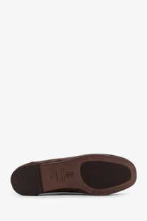 Brown leather shoe sole with matte finish and embossed brunello cucinelli logo on women’s suede loafers back side