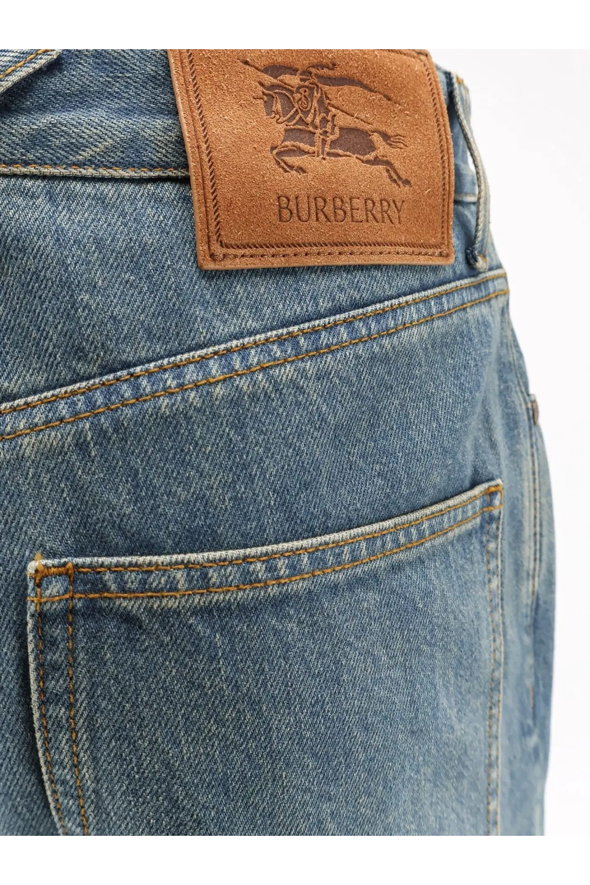 Back view of burberry men’s dexter blue denim jeans with a brown leather patch featuring the knight logo and brand name
