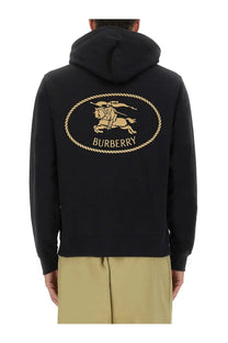 Black Burberry men’s hoodie featuring a gold embroidered horse and rider logo within an oval rope border