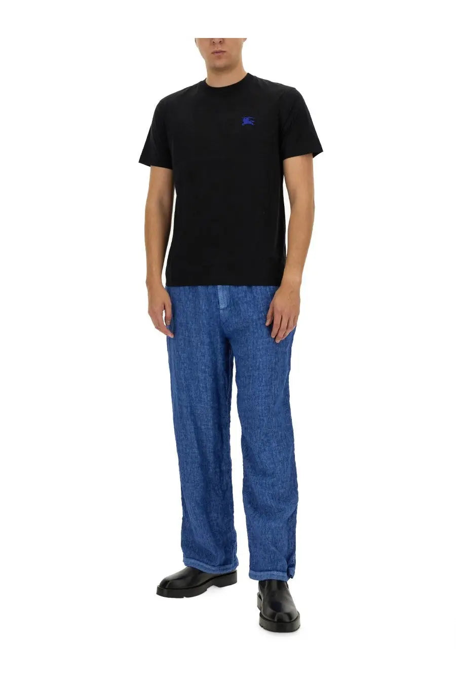 Black short-sleeved t-shirt with small embroidered blue logo on left chest paired with Burberry men’s blue linen pants