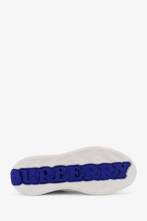 White rubber sole with bold blue embossed burberry logo on burberry men’s low top white leather sneakers