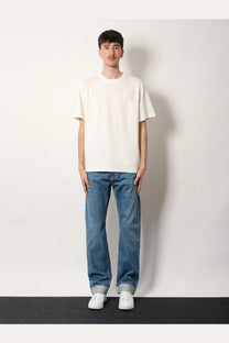 A man wearing a Burberry men’s Ryan organic cotton white short-sleeved crew neck t-shirt with blue jeans and white sneakers