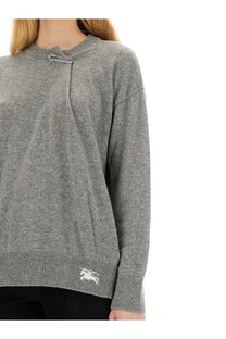 Burberry women’s grey cashmere sweater with silver safety pin neckline and white embroidered logo on cuff