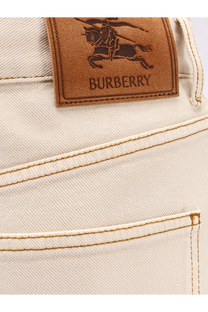 Cream-colored burberry women’s denim trousers with a brown leather patch featuring the burberry knight logo on back