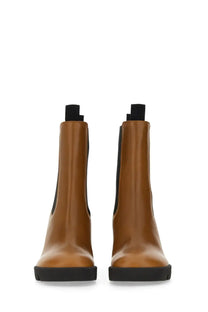 Burberry women’s beige leather chelsea boots with tan leather, black rubber soles, and elastic side panels