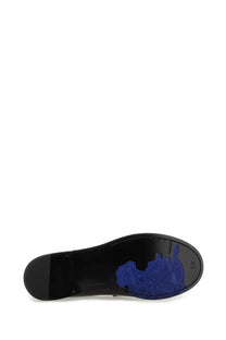 Black rubber sole of burberry women’s moccasin cadet featuring vibrant blue embossed horse design