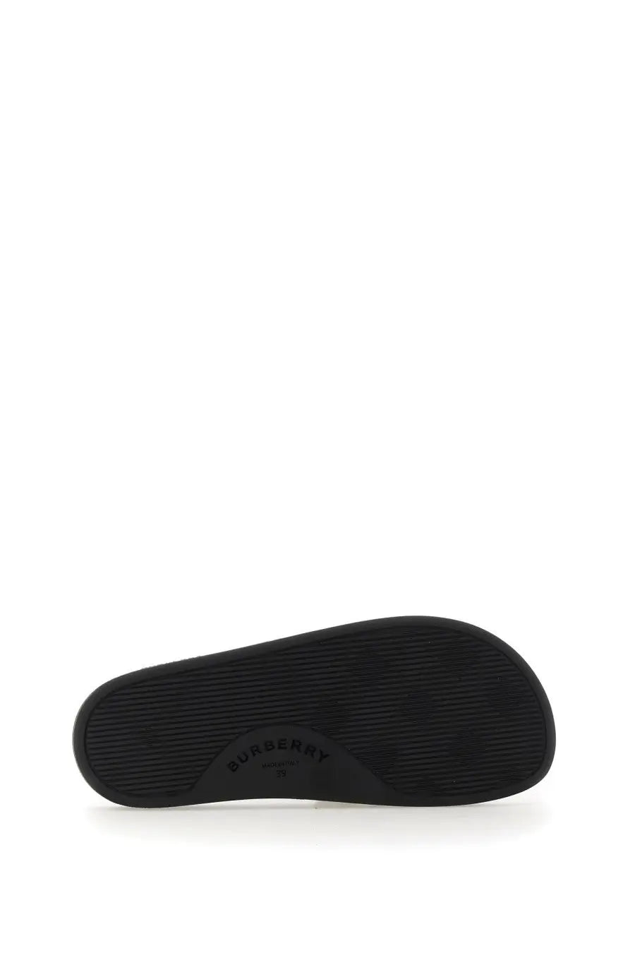 Black rubber sole of burberry women’s beige slide sandal shown from the back side