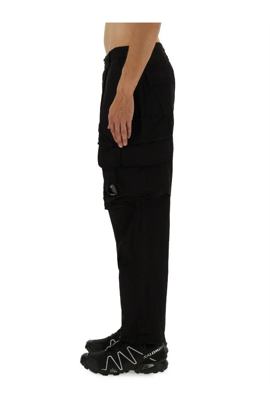 Black c.p. company men’s cargo pants with multiple pockets and subtle logo on the thigh in durable fabric