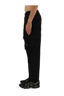 Black c.p. company men’s cargo pants with multiple pockets and subtle logo on the thigh in durable fabric