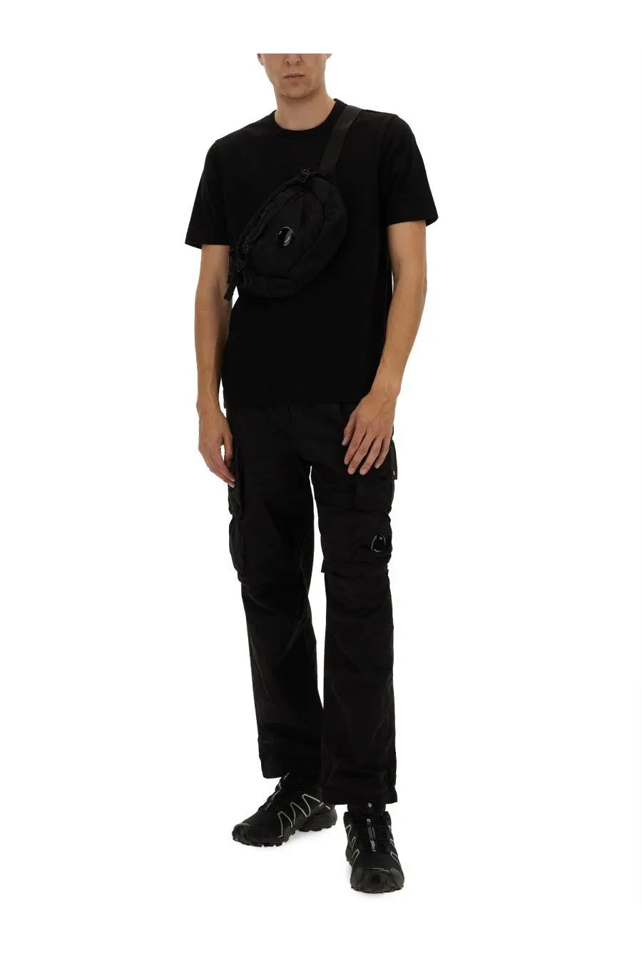 Black tactical-style crossbody bag with minimalist logo on front paired with c P Company men’s cargo pants black