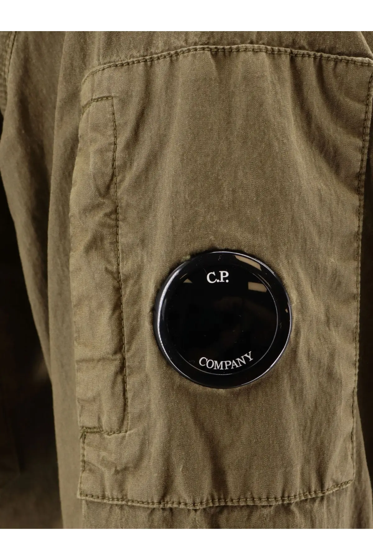 Olive green canvas cargo pants with black circular c.p. logo featured in c.p. company cotton blend sahariana jacket dried herb