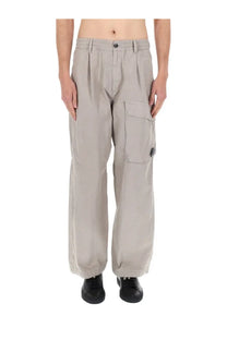 C.P. Company men’s beige cargo pants with a relaxed fit feature multiple pockets and button closures
