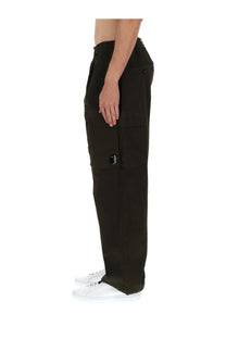 Dark olive c p company men’s pantalone cargo pants with multiple pockets and black circular logo on the thigh