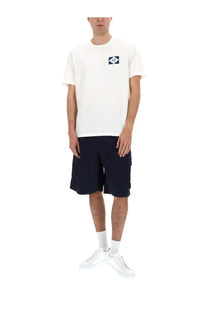 White cotton t-shirt with small navy blue logo patch on left chest paired with c.p. company mens cargo shorts blue