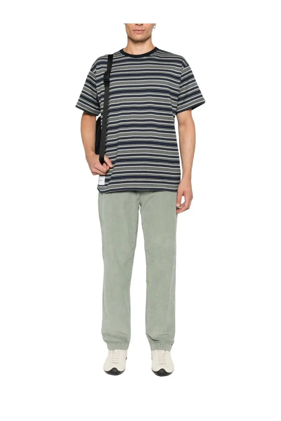 A short-sleeved t-shirt with navy blue gray and white horizontal stripes shown with c.p. company men’s green velvet chino pants