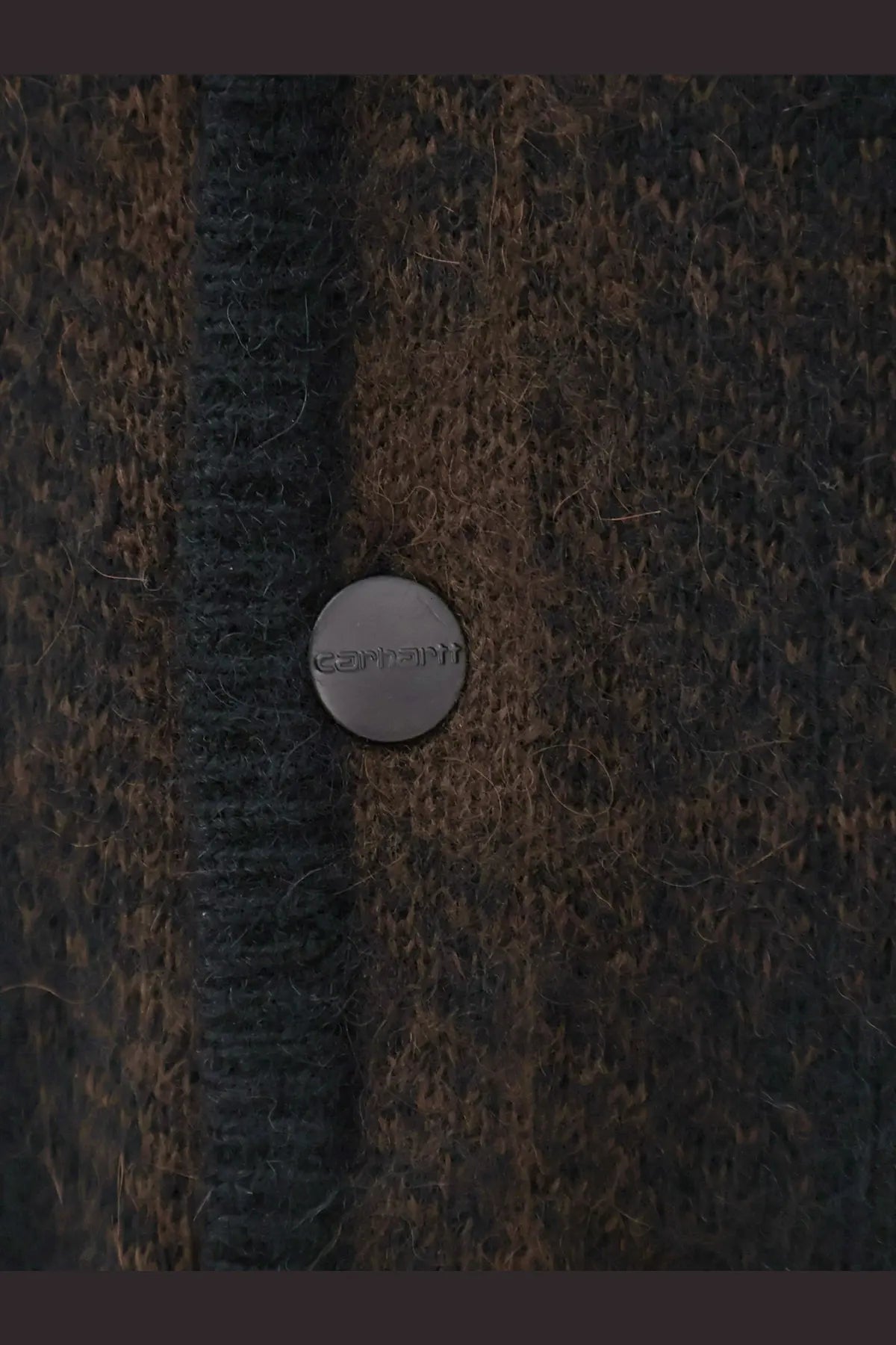 A silver Carhartt button on a dark brown and black alpaca blend knit cardigan for men