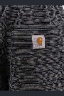 Black and white striped carhartt work shirt with tan logo patch on chest pocket paired with relaxed fit shorts