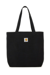 Black canvas tote bag featuring a white square logo patch with an orange carhartt emblem for men
