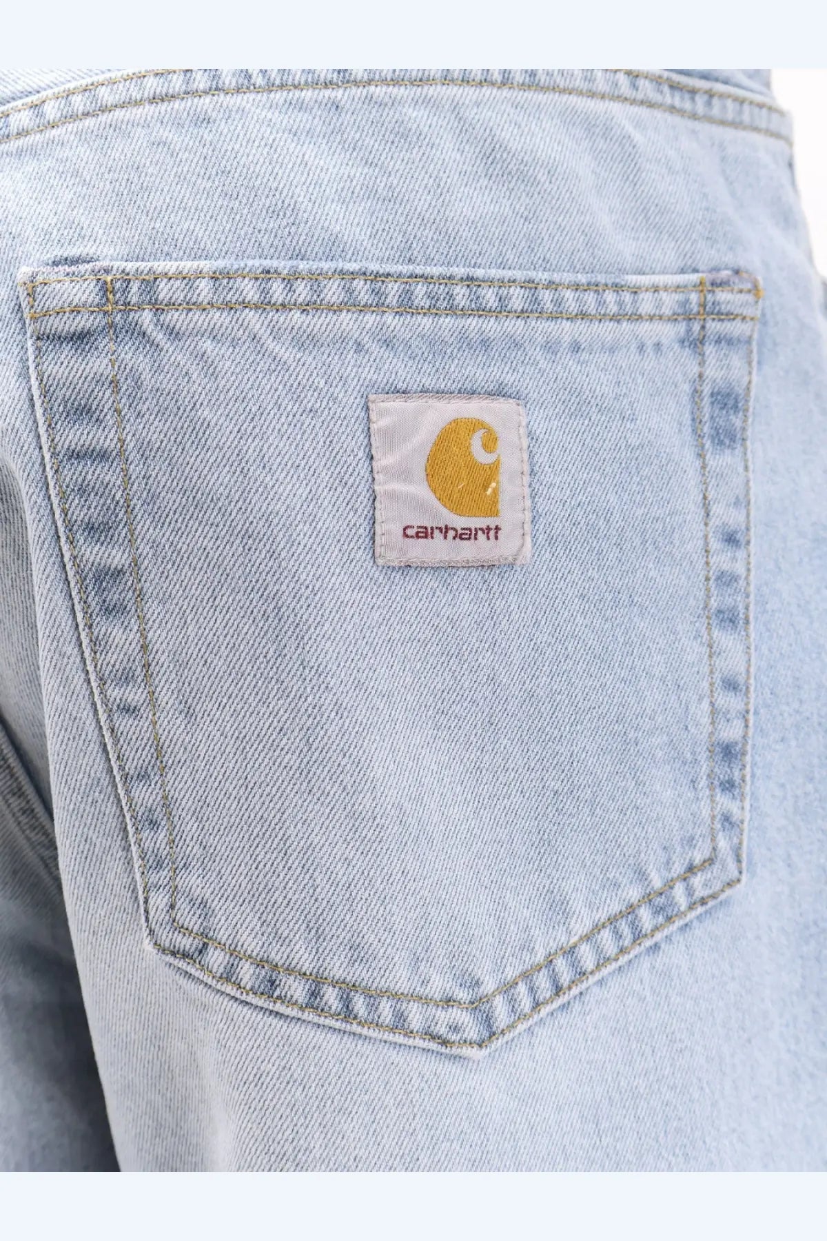 Back side of carhartt wip men’s landon light-wash denim jeans with classic pocket and white patch logo
