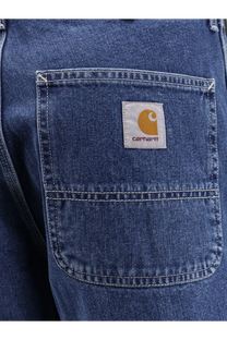 Back side of blue denim carhartt wip men’s norco relaxed straight fit jeans with white patch and orange logo on pocket