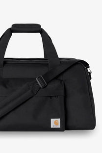 Black Carhartt Wip men’s nylon duffel bag with sturdy fabric and contrasting orange logo patch