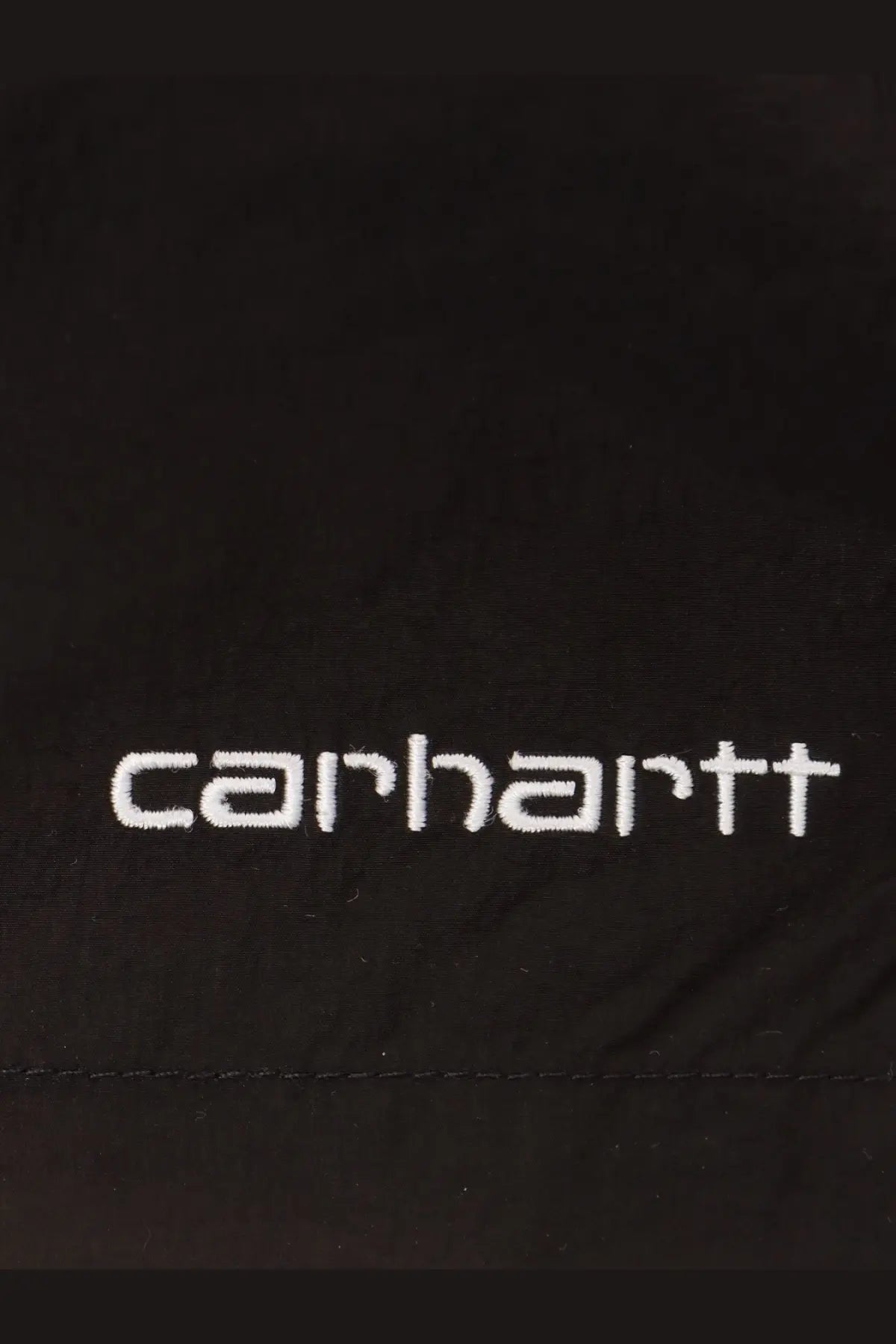 Black carhartt jacket with white embroidered logo paired with carhartt wip men’s black nylon swim trunk
