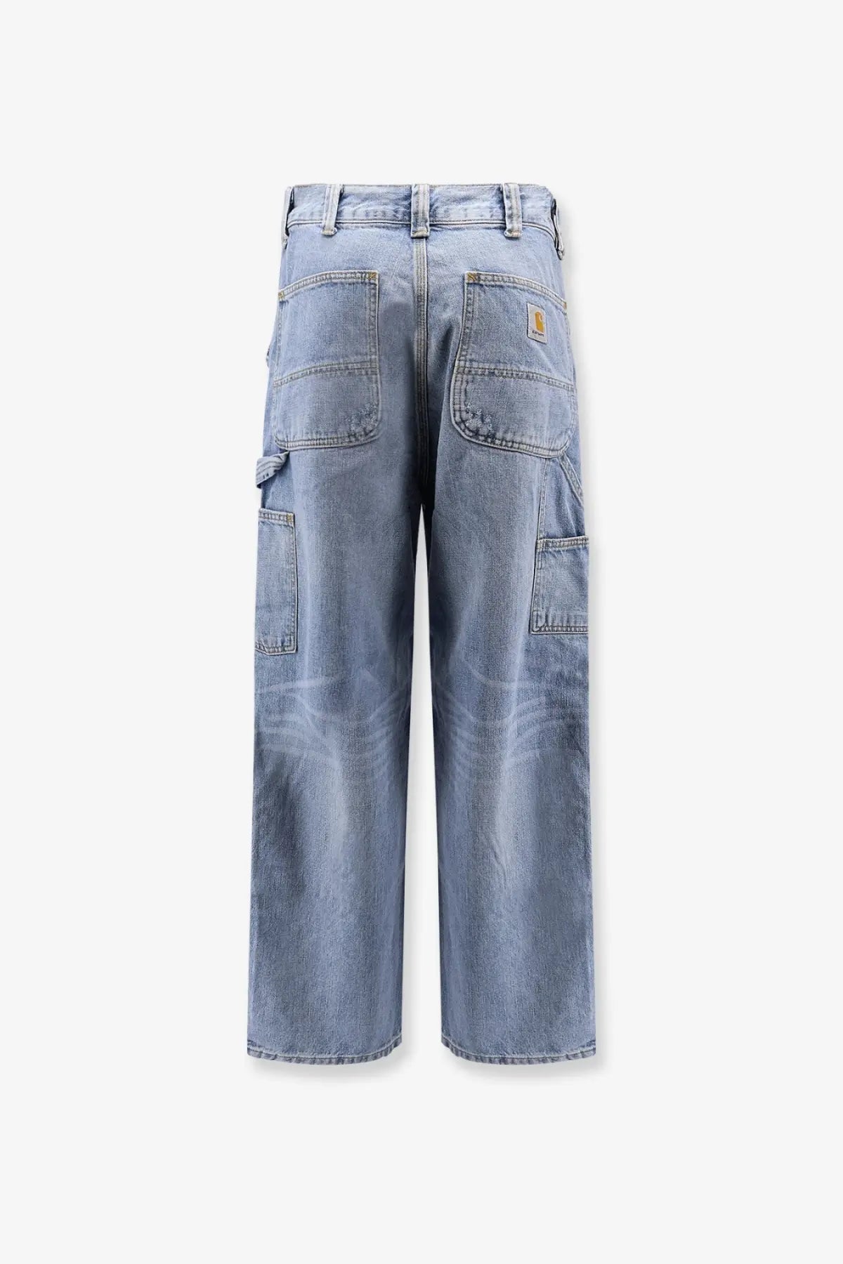 Back view of light-wash denim cargo pants with multiple pockets and carhartt logo patch on the back right pocket