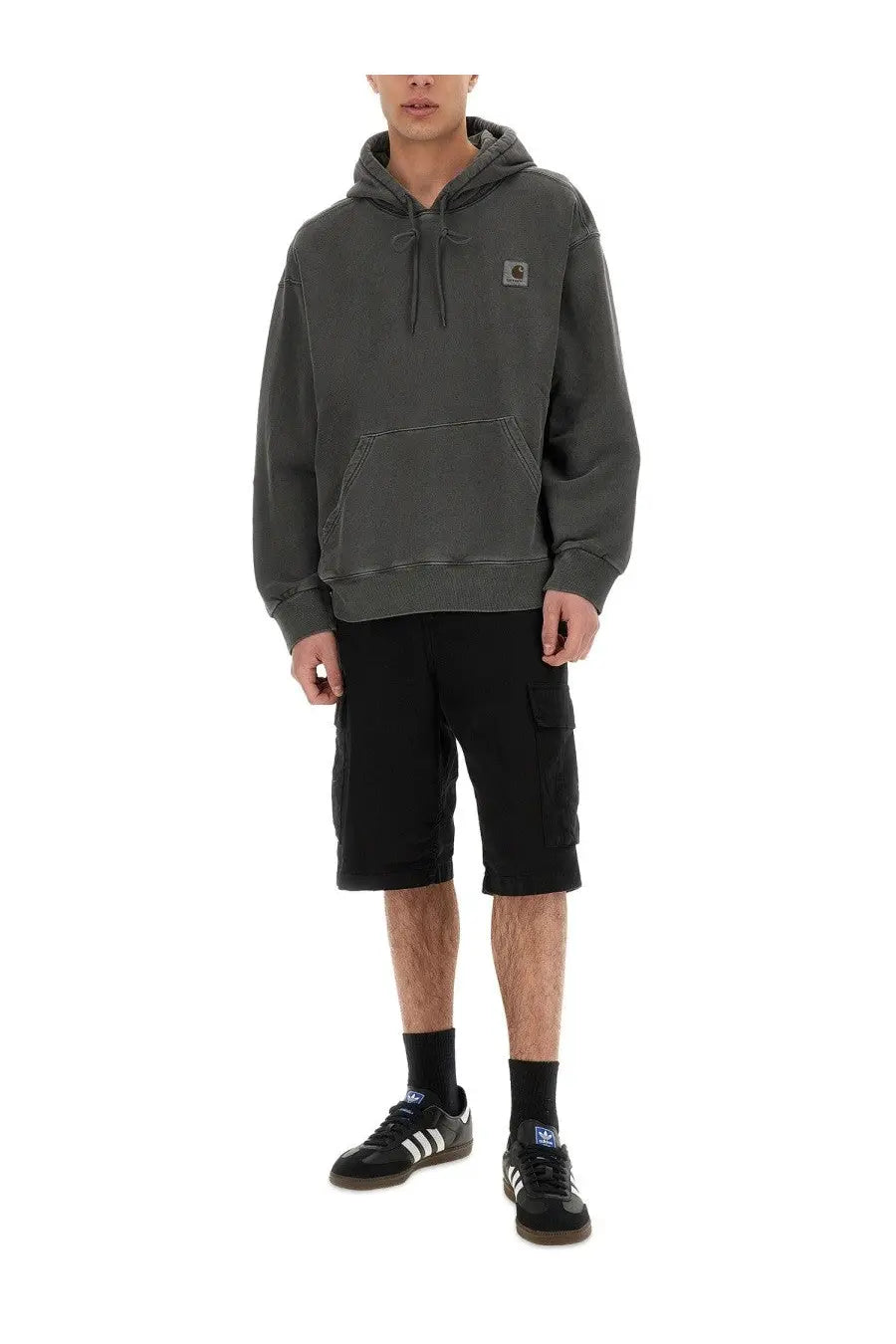 Dark gray carhartt wip men’s hoodie with small chest logo patch paired with short black cargo pants