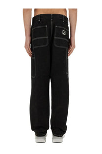 Back view of carhartt Wip men’s black single knee cargo pants with white stitching and logo patch on right pocket