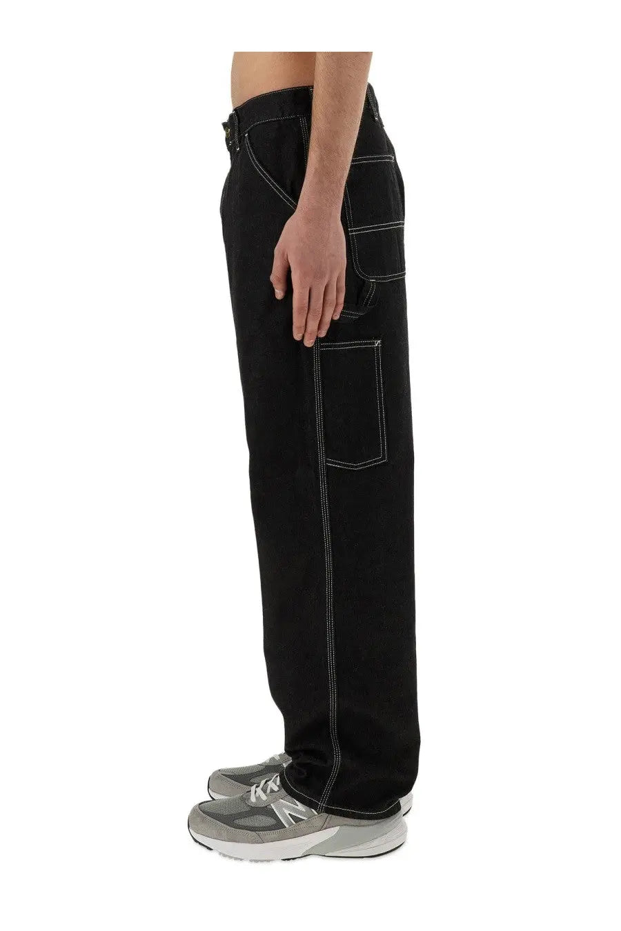 Carhartt Wip men’s single knee black denim pants with white stitching and multiple pockets for durability and utility