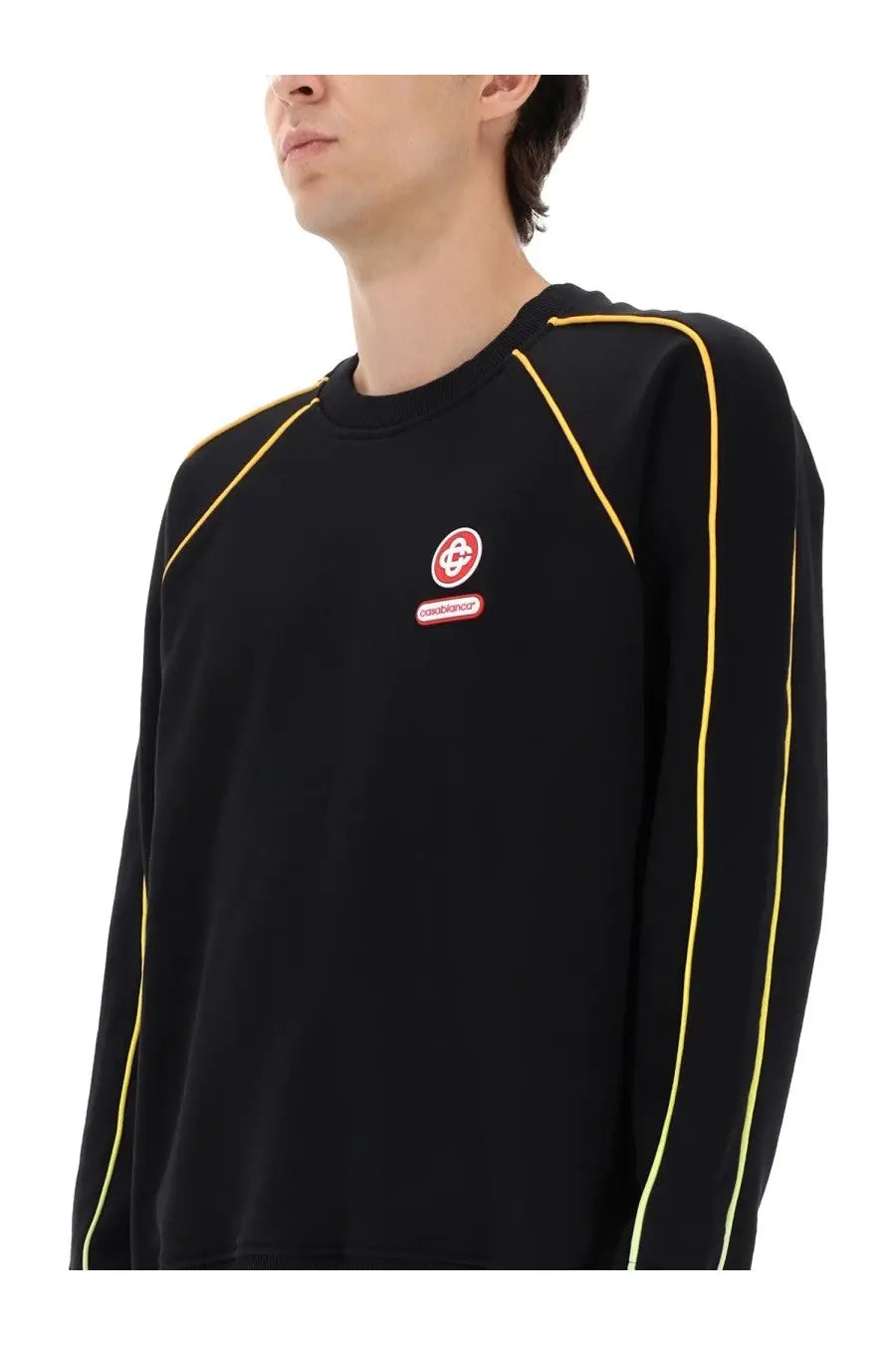 Casablanca men’s black crewneck sweatshirt with bold yellow seam detailing and small red circular logo patch on chest