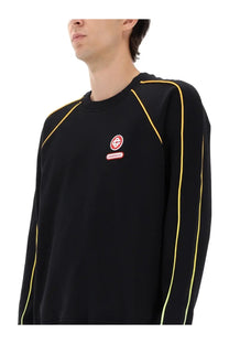 Casablanca men’s black crewneck sweatshirt with bold yellow seam detailing and small red circular logo patch on chest