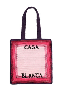 A vibrant pink and navy blue crocheted tote bag with black embroidered casa blanca lettering for men
