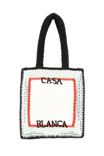 Black and white crocheted tote bag with red embroidered border and casa blanca text in unisex design
