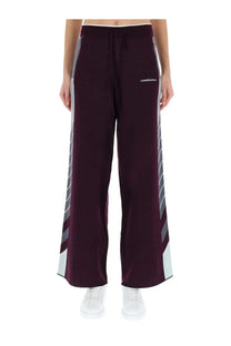 Casablanca women’s purple wide-leg track pants with gray and white diagonal stripes and drawstring waistband