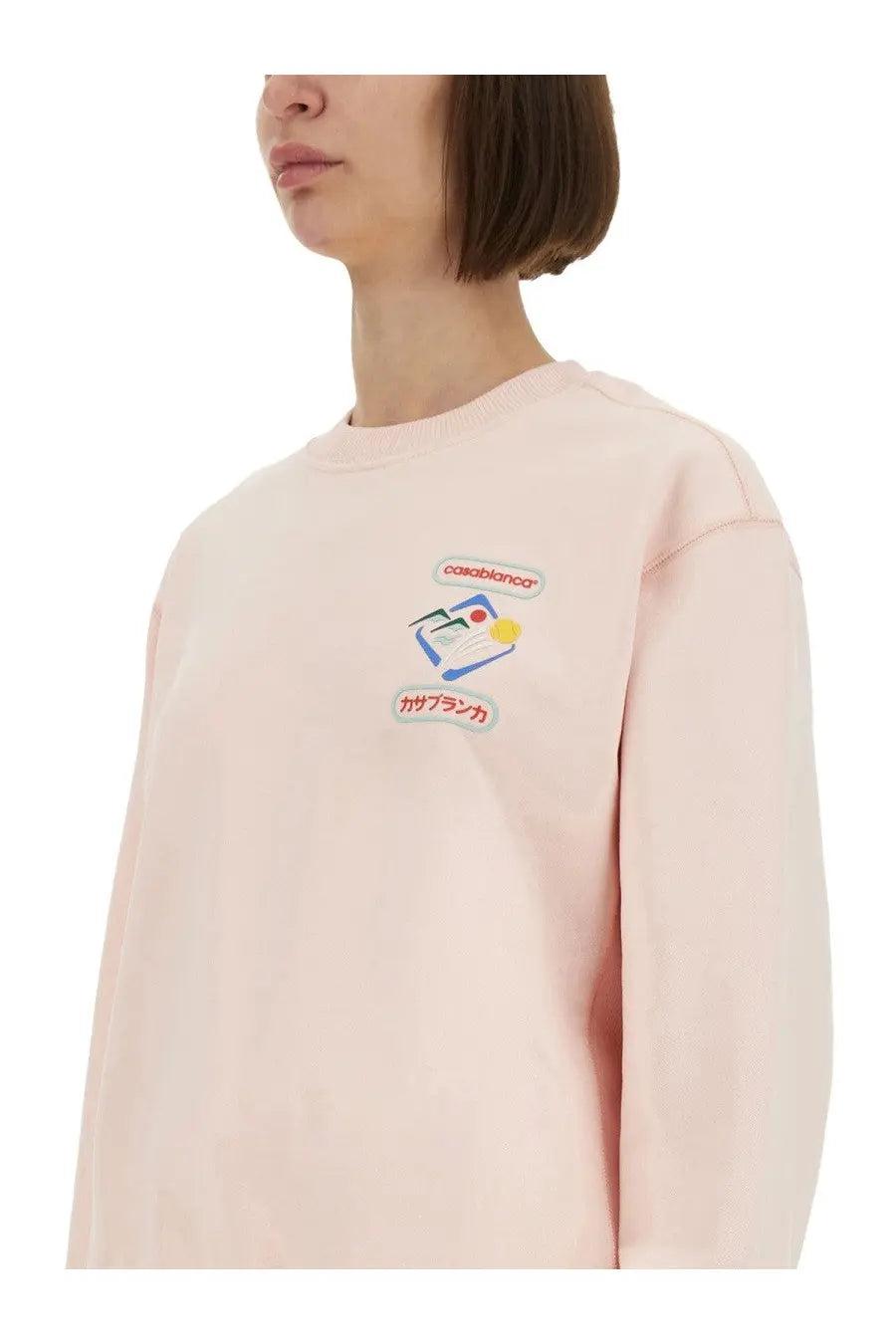 A soft pink casablanca women’s montagne sportif sweatshirt with long sleeves and colorful embroidered notebook graphic