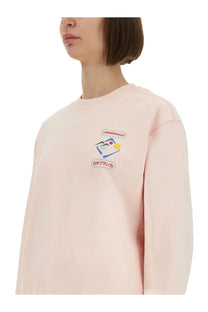 A soft pink casablanca women’s montagne sportif sweatshirt with long sleeves and colorful embroidered notebook graphic