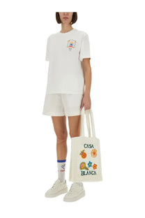White canvas tote bag with colorful embroidered patches and casa blanca print for casual use