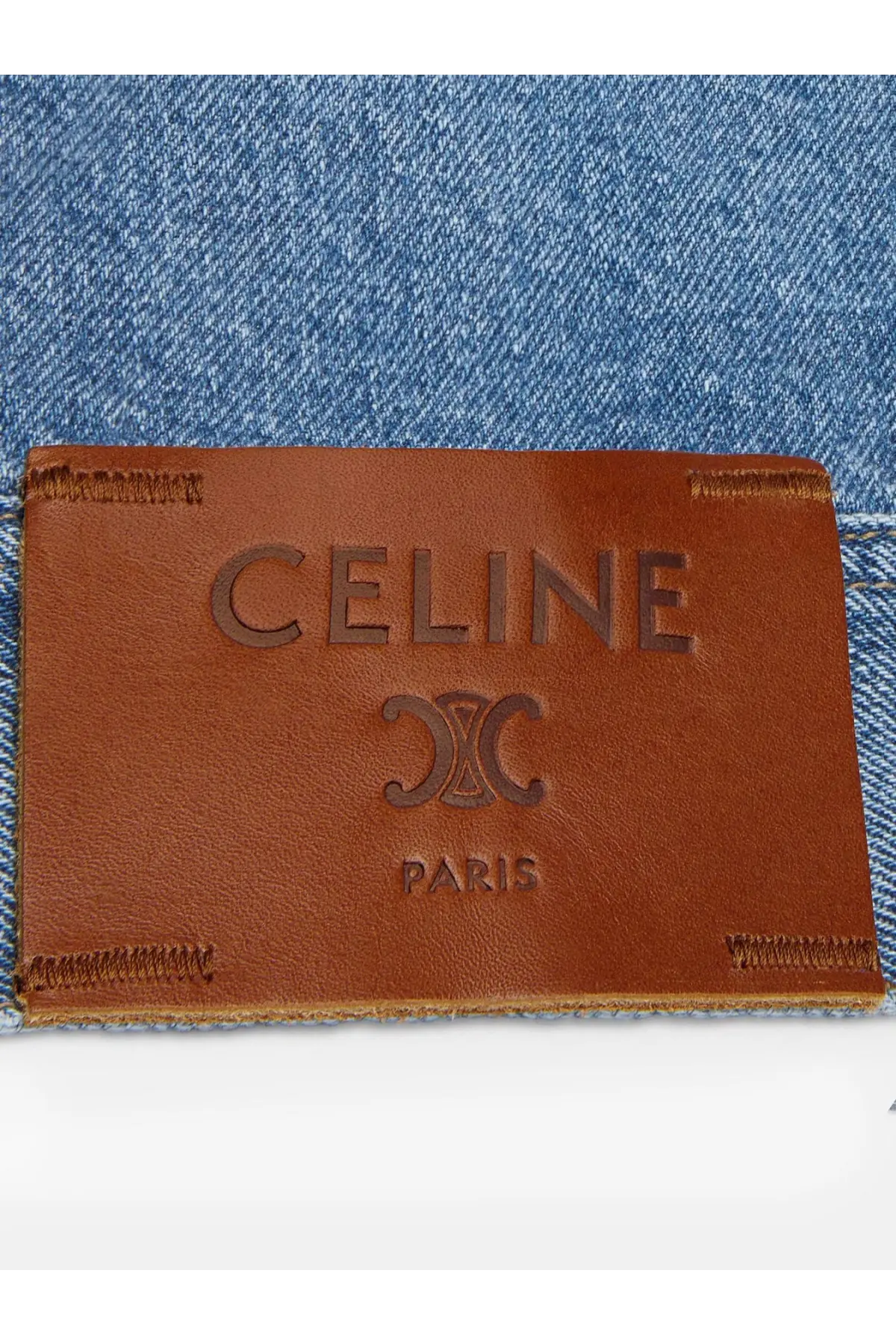 Brown leather celine paris label with embossed logo and stitching on celine men’s blue denim jacket blue