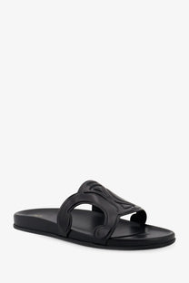 Black leather slide sandal featuring an ornate embossed strap design from celine men’s triomphe collection
