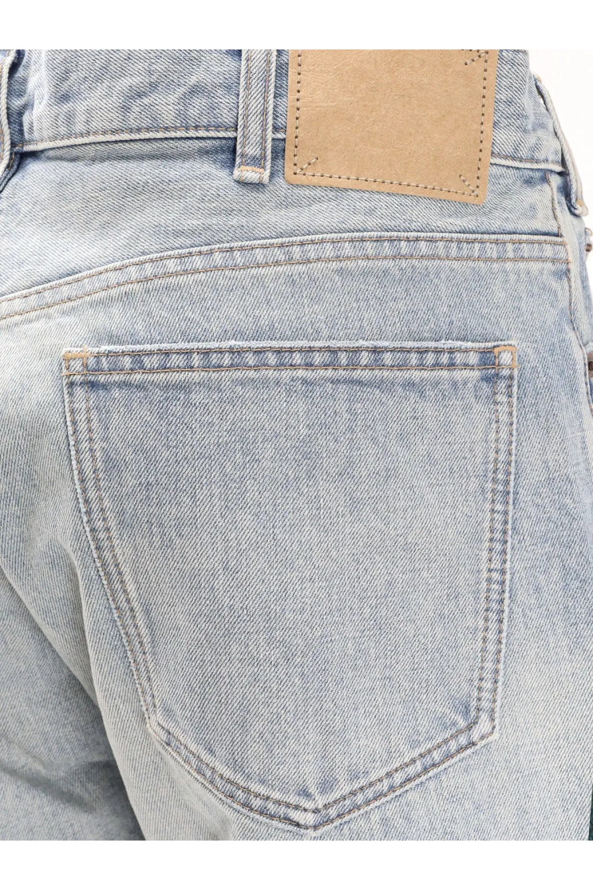 Back side of celine men’s wesley zuma wash denim jeans in light-wash denim with classic pocket stitching and tan leather patch